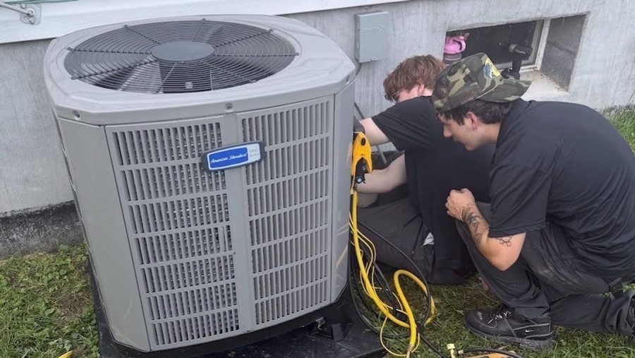 HVAC tech repairing air conditioning unit.