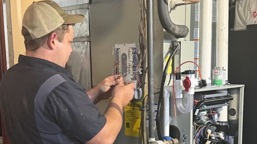 Electrician performing an electrical safety inspection on home equipment.