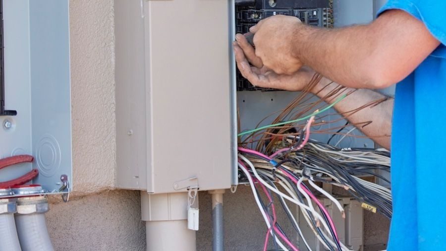 Electrician rewiring electrical box.